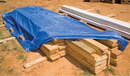 Blue economy tarp covering lumber; representative application, not a size illustration
